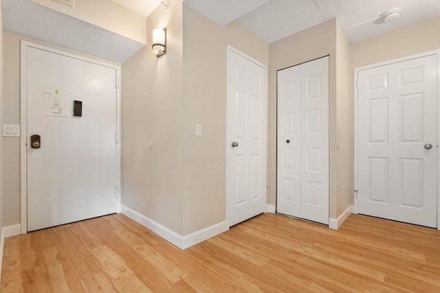 entrance foyer featuring light wood finished floors and baseboards