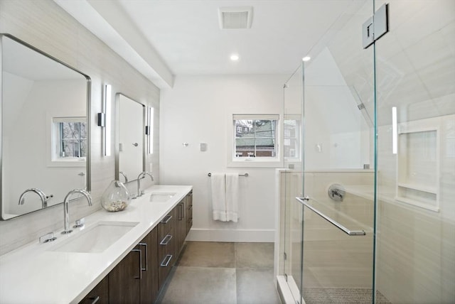 full bathroom featuring a sink, visible vents, a shower stall, and plenty of natural light