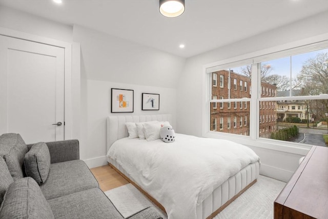 bedroom with wood finished floors, baseboards, lofted ceiling, and recessed lighting