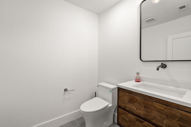 bathroom featuring visible vents, toilet, vanity, and baseboards