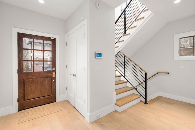 foyer entrance with baseboards, recessed lighting, wood finished floors, and stairs