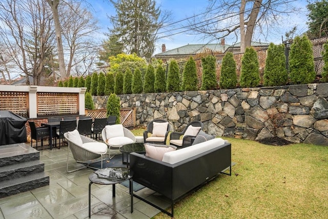 view of patio featuring fence, a grill, outdoor dining area, and an outdoor hangout area