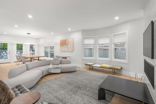 living area featuring light wood-style floors, baseboards, and recessed lighting