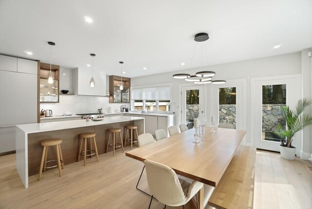 dining space with light wood-type flooring, a notable chandelier, and recessed lighting