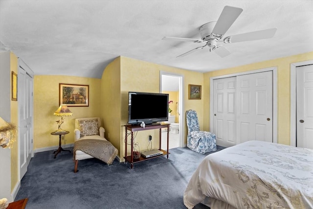 carpeted bedroom featuring multiple closets and ceiling fan