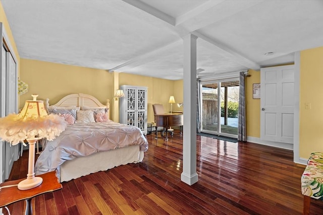 bedroom with access to exterior, dark wood-type flooring, decorative columns, and beamed ceiling