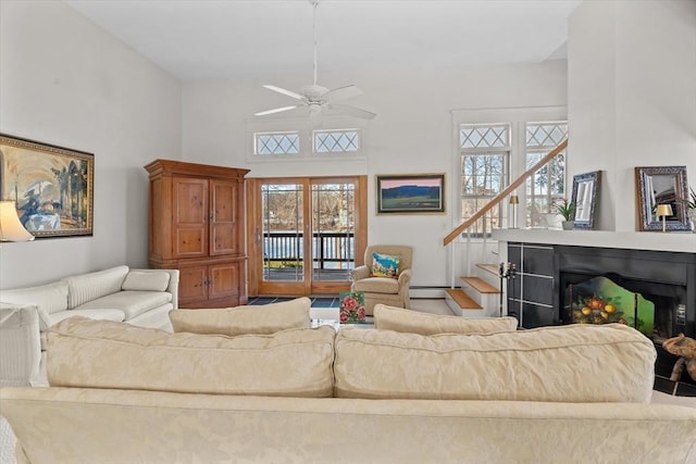 living room with a towering ceiling and ceiling fan