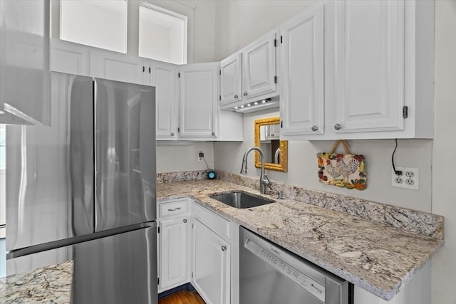 kitchen featuring white cabinetry, sink, light stone counters, and stainless steel appliances