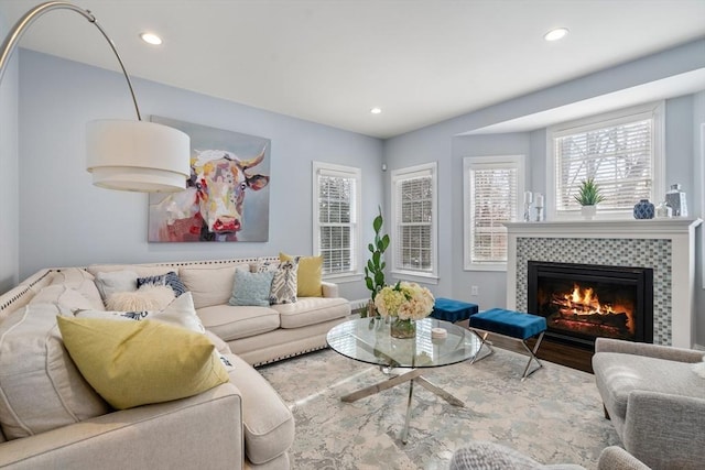 living room featuring a tiled fireplace and wood-type flooring