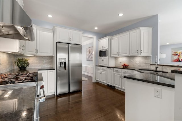 kitchen with built in appliances, white cabinetry, and island exhaust hood