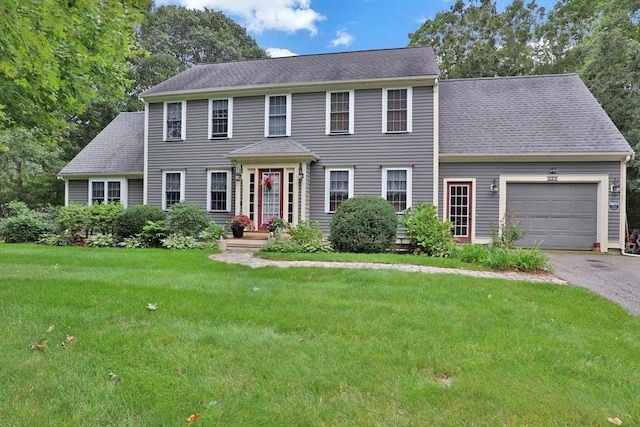 colonial home with a garage and a front lawn