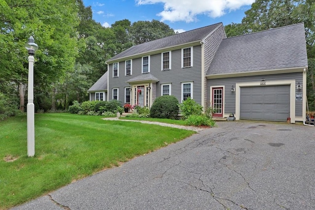 colonial inspired home with a front yard and a garage