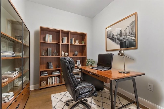 office space with baseboards and wood finished floors