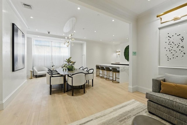 dining room featuring baseboards, wood finished floors, crown molding, a chandelier, and recessed lighting