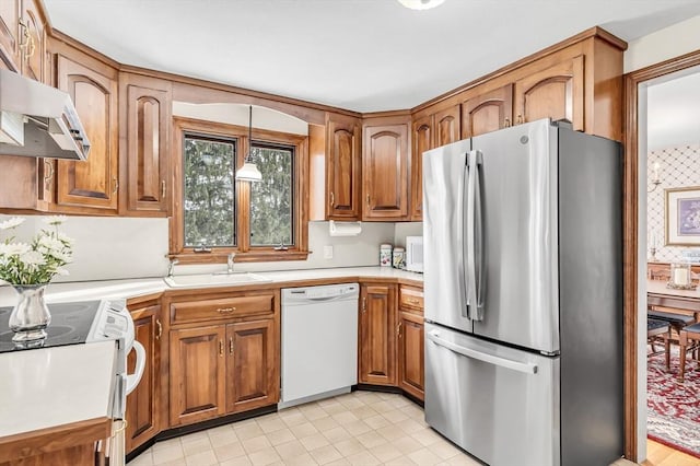 kitchen featuring range with electric stovetop, light countertops, hanging light fixtures, freestanding refrigerator, and white dishwasher