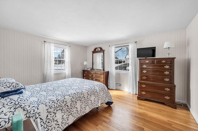 bedroom with multiple windows and light wood-style flooring