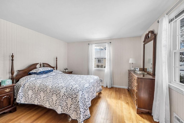 bedroom featuring visible vents, light wood-style flooring, and baseboards