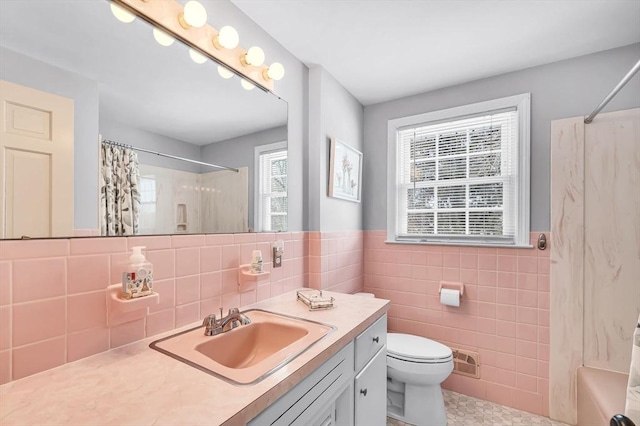 bathroom featuring toilet, tile walls, vanity, visible vents, and shower / tub combo with curtain