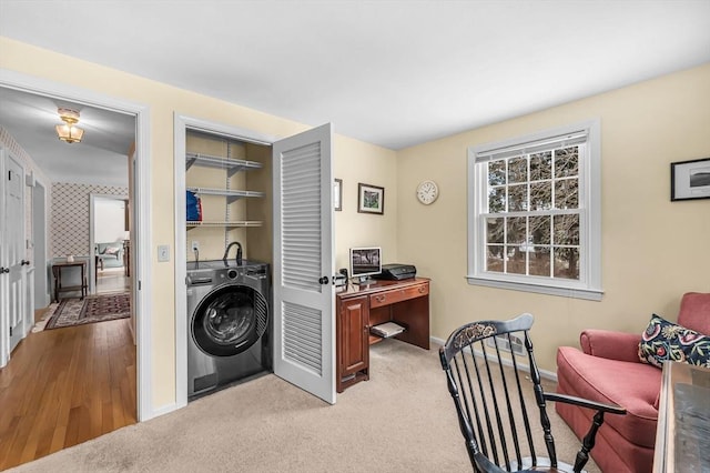 office area featuring light carpet, baseboards, and washer / clothes dryer