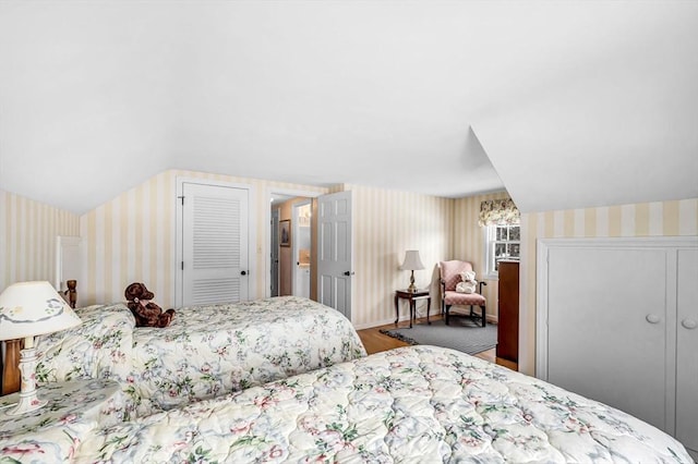 bedroom featuring wallpapered walls, a closet, and wood finished floors