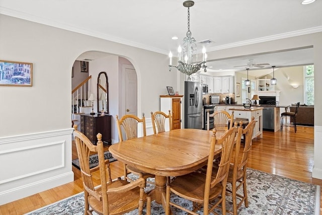 2 Christin Way, Woburn, MA 01801 - dining area featuring arched walkways, light wood-style floors, crown molding, recessed lighting, and a chandelier