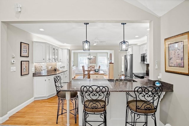 2 Christin Way, Woburn, MA 01801 - kitchen featuring appliances with stainless steel finishes, a peninsula, a kitchen breakfast bar, dark stone counters, and recessed lighting