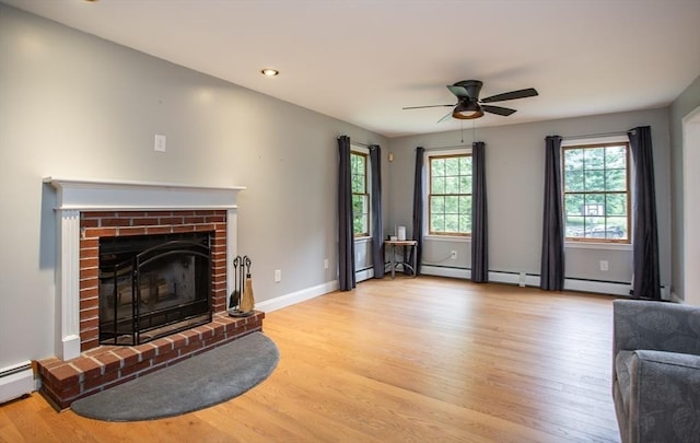 16 Austin Ln, Acushnet, MA 02743 - unfurnished living room with light wood-style floors, a ceiling fan, a brick fireplace, a baseboard radiator, and recessed lighting