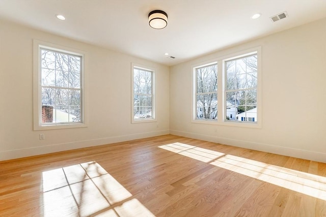 unfurnished room with a healthy amount of sunlight and light hardwood / wood-style flooring