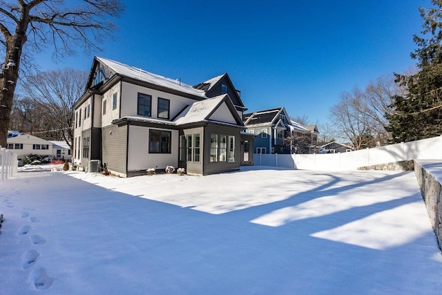 snow covered rear of property with central air condition unit