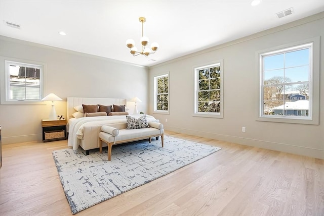 bedroom with ornamental molding, light hardwood / wood-style floors, multiple windows, and a notable chandelier