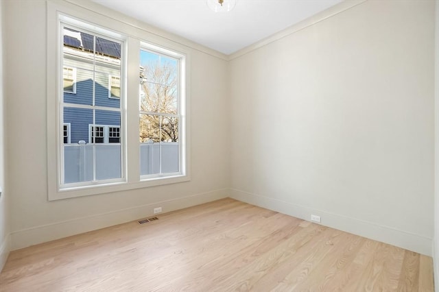 unfurnished room featuring ornamental molding and light hardwood / wood-style floors