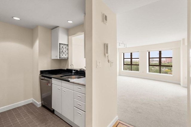 931 Massachusetts Ave Unit 1003, Cambridge, MA 02139 - kitchen with stainless steel dishwasher, white cabinetry, dark countertops, recessed lighting, and dark colored carpet