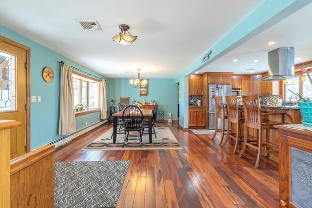 dining area featuring dark wood-style flooring, a notable chandelier, visible vents, recessed lighting, and a baseboard heating unit