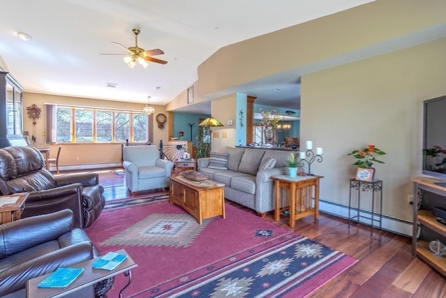 living area with baseboard heating, vaulted ceiling, wood finished floors, and a wealth of natural light