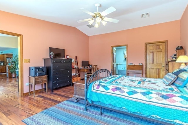 bedroom with visible vents, wood finished floors, connected bathroom, a ceiling fan, and vaulted ceiling