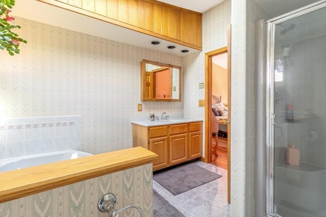 full bath with vanity, tile patterned floors, a stall shower, and wallpapered walls