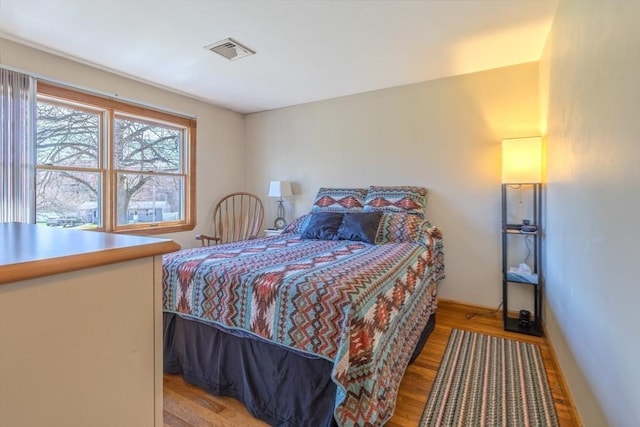 bedroom with visible vents and wood finished floors