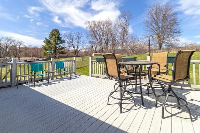 wooden terrace with a yard and outdoor dining space