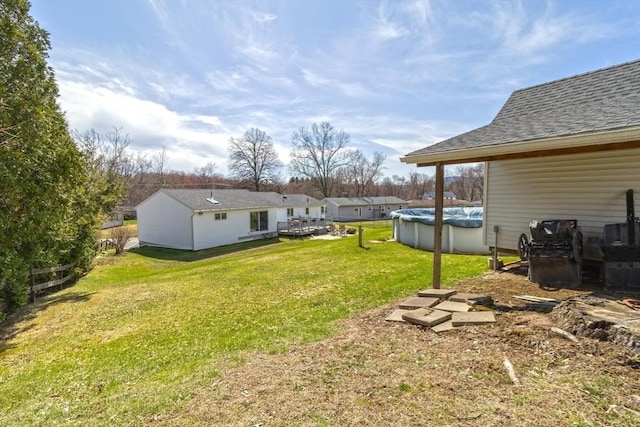 view of yard with a wooden deck and a covered pool