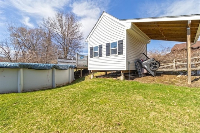 back of house with a lawn, a covered pool, and a deck