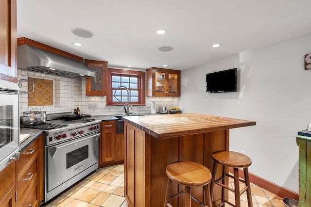 164 Water St Unit 164, Newburyport, MA 01950 - kitchen featuring premium range, wall chimney range hood, brown cabinetry, a breakfast bar, and wood counters