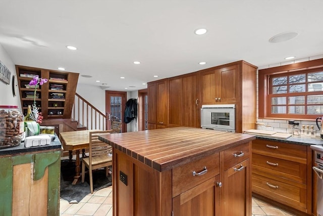 164 Water St Unit 164, Newburyport, MA 01950 - kitchen with butcher block counters, light tile patterned floors, oven, tasteful backsplash, and recessed lighting