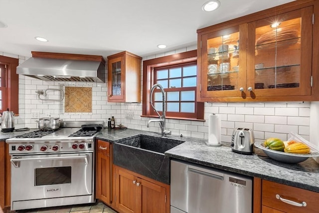 164 Water St Unit 164, Newburyport, MA 01950 - kitchen with appliances with stainless steel finishes, wall chimney exhaust hood, a sink, brown cabinetry, and tasteful backsplash