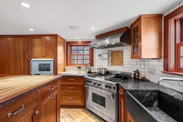 164 Water St Unit 164, Newburyport, MA 01950 - kitchen with designer range, wall chimney range hood, brown cabinets, and recessed lighting