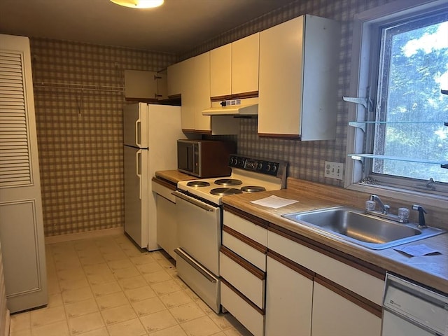 kitchen with white cabinets, white appliances, and sink