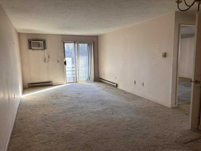 carpeted spare room featuring a wall mounted AC, a baseboard radiator, and a textured ceiling