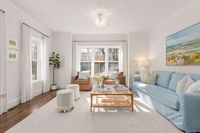 living room with baseboards, wood finished floors, visible vents, and ornamental molding