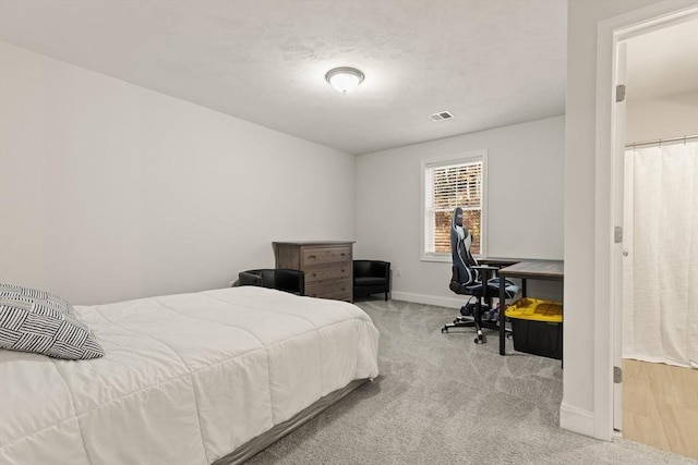 carpeted bedroom featuring baseboards and visible vents
