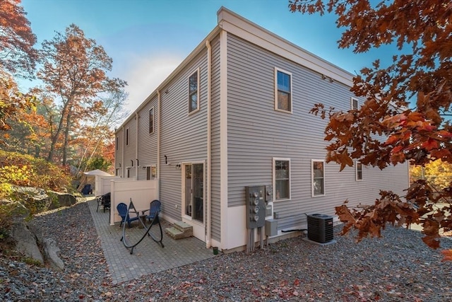 rear view of property with a patio area, central air condition unit, and fence