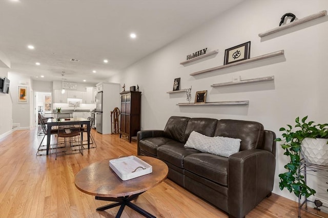 living room featuring recessed lighting, visible vents, and light wood-type flooring